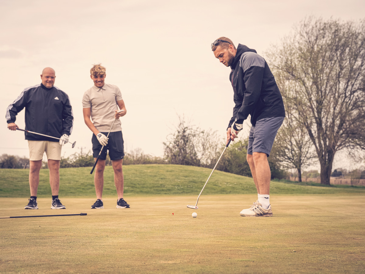 3 males on a golf course